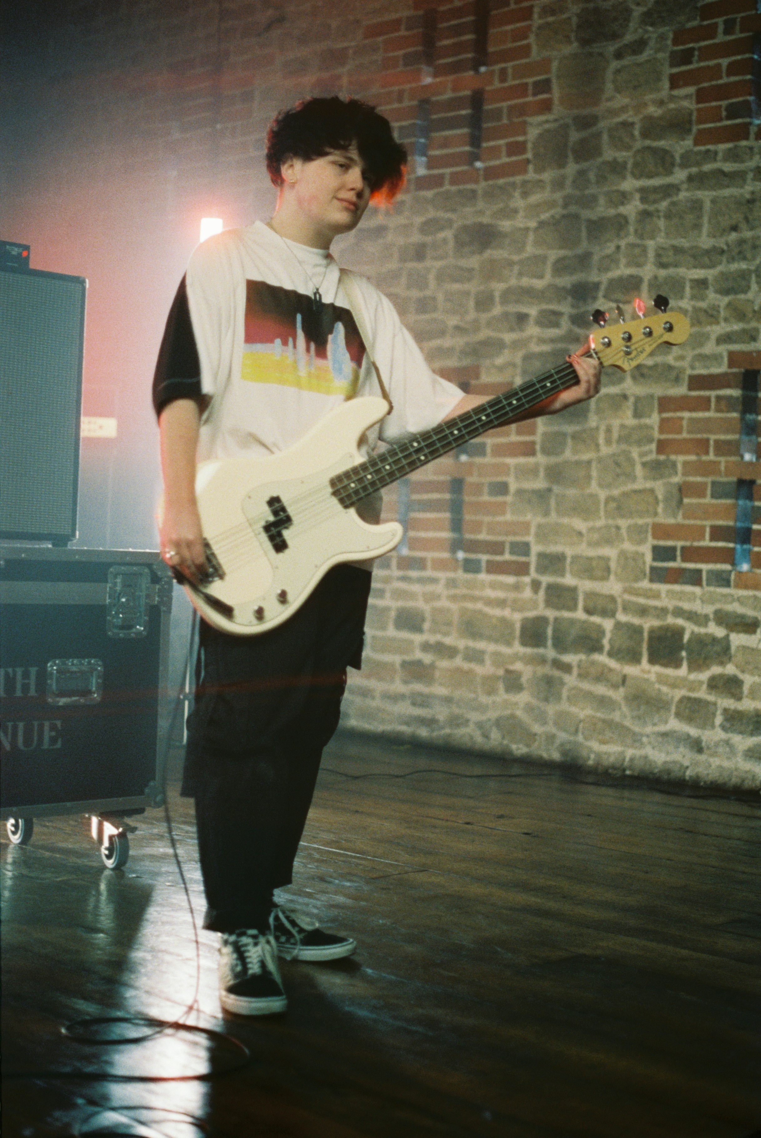 man in white shirt playing electric guitar